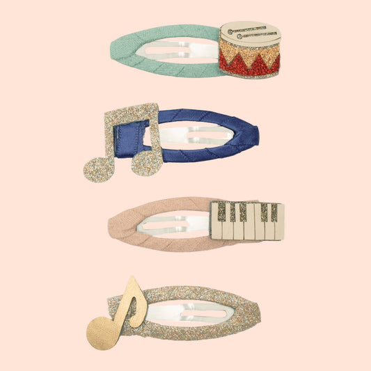 Set of five decorative hair clips with musical note designs on a white background